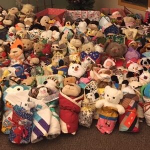 Pile of teddy bears and stuffies wrapped in quilts Photo showing 200+ stuffed toys wrapped in individual quilts