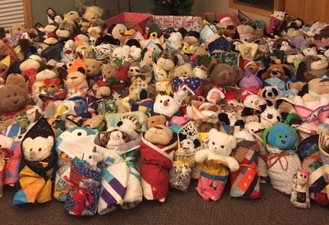 Pile of teddy bears and stuffies wrapped in quilts Photo showing 200+ stuffed toys wrapped in individual quilts